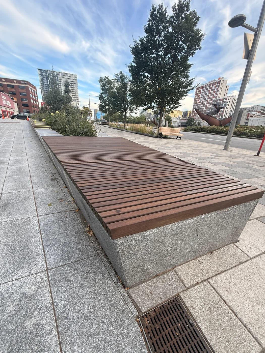 Wooden seating beside planting beds at Place Banque Nationale.
