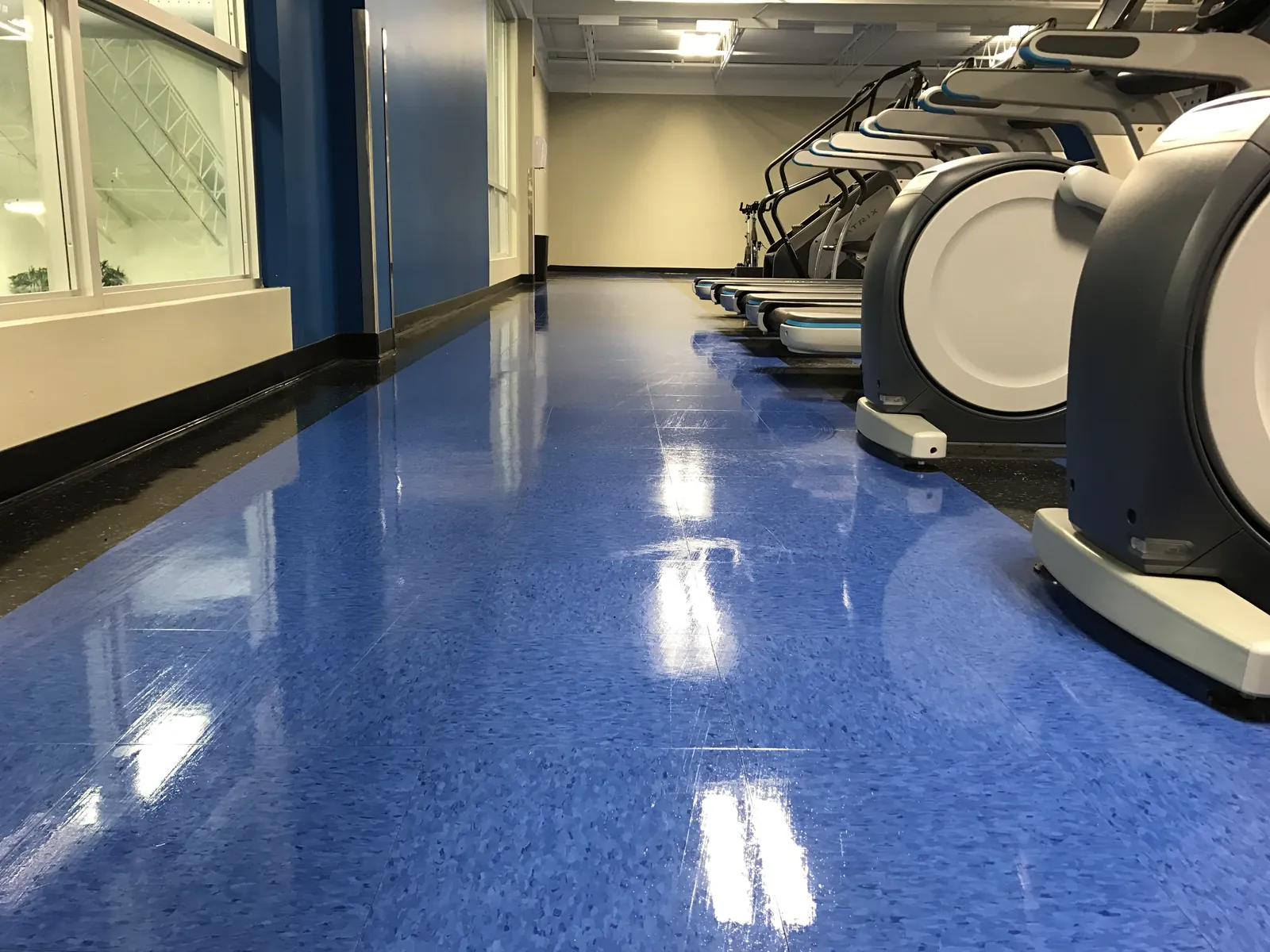 A polished blue floor alongside fitness equipment.
