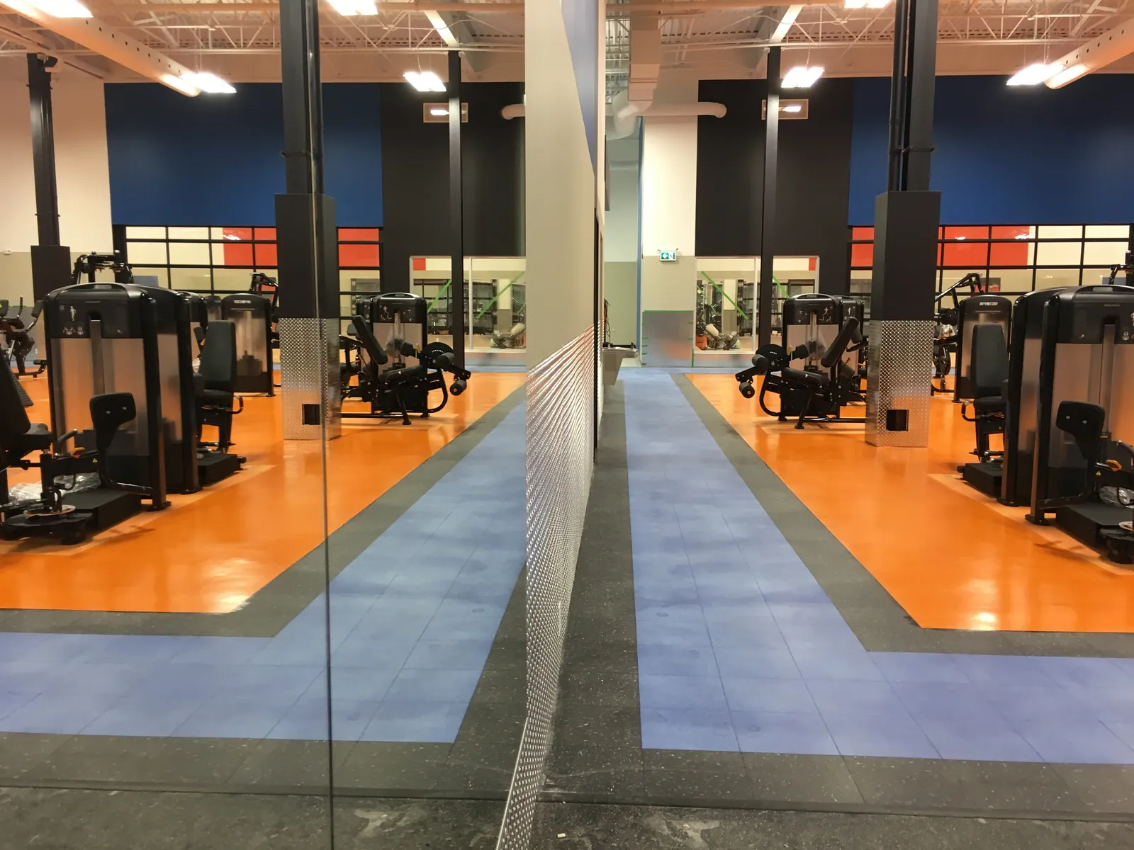 Orange and blue flooring among fitness equipment.