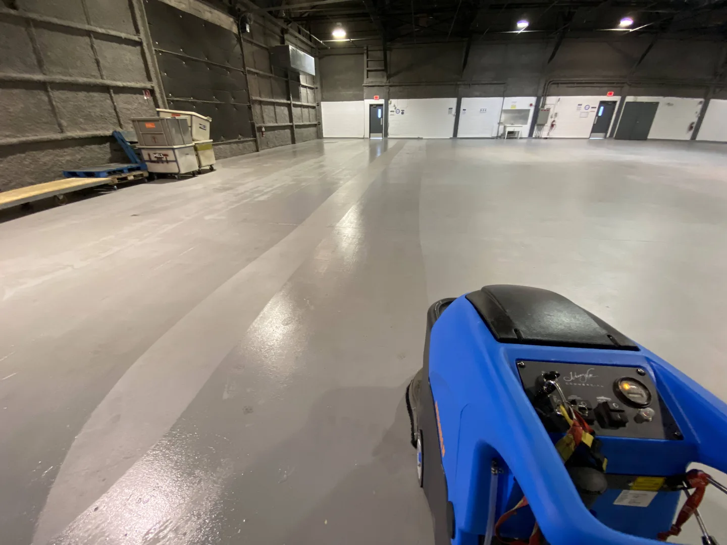 Blue floor scrubber on the floor of the hangar used for the gala.