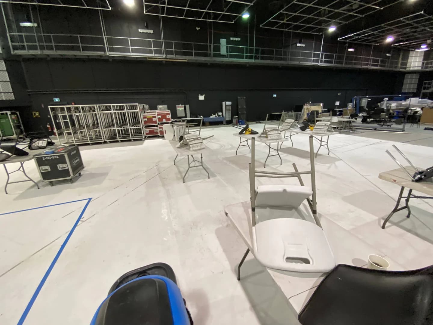 Cleaning equipment in front of tables and chairs in the hangar.