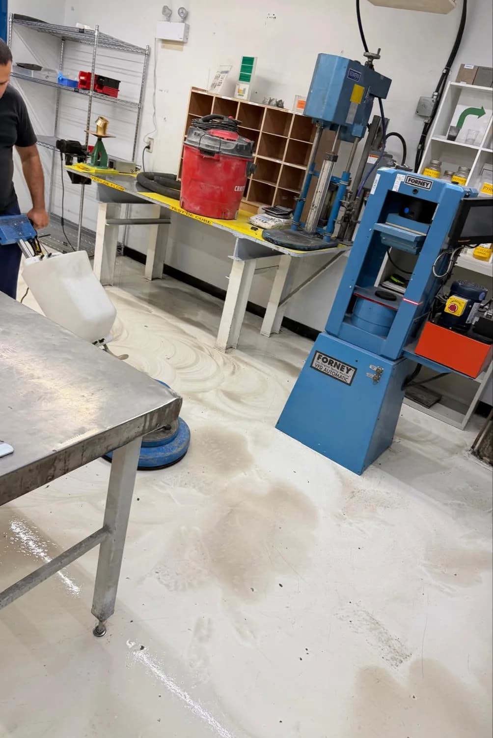 Floor restoration in progress around testing equipment in the Oldcastle quality laboratory in Candiac.