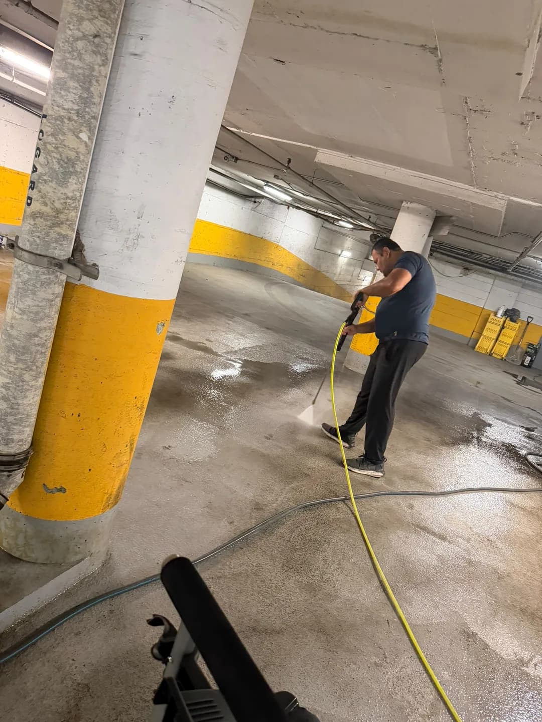 A Push Push team member pressure washes the CAPREIT parking garage floor at 2250 Guy Street in Montréal.