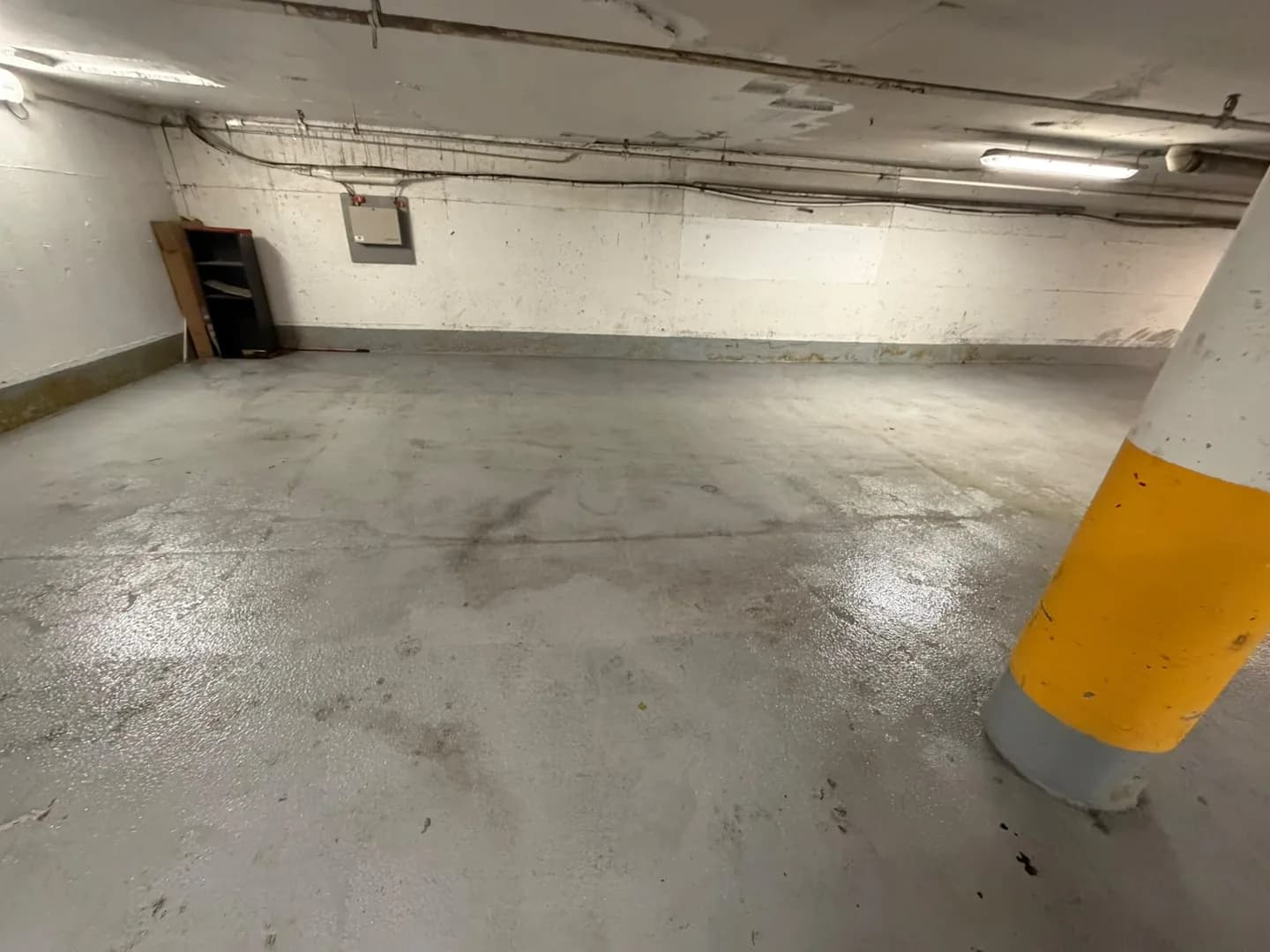 View of a parking area with a concrete floor and yellow columns at 2250 Guy Street in Montréal.